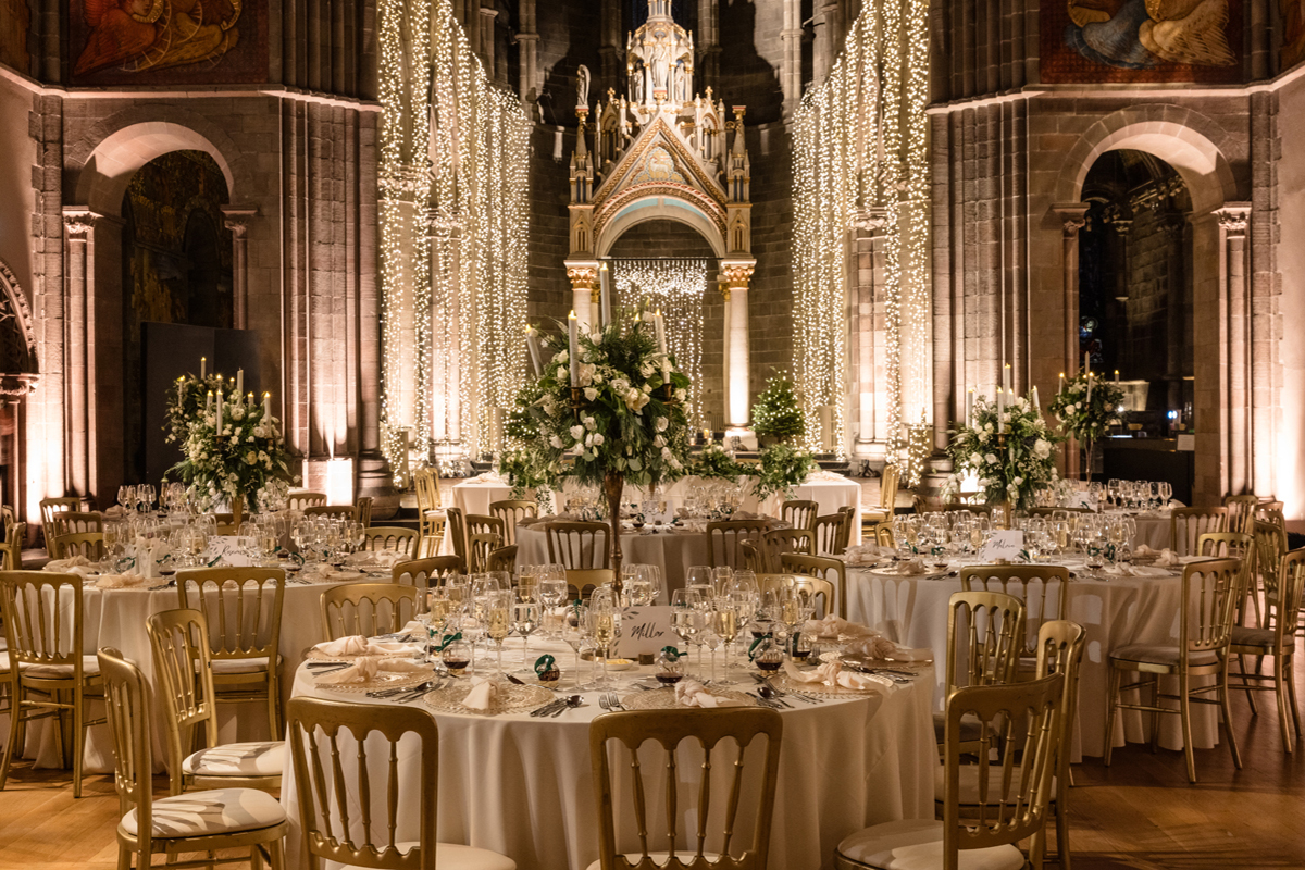 Grand wedding dinner setup inside Mansfield Traquair, Edinburgh, with gold chairs, floral centrepieces and cascading fairy lights