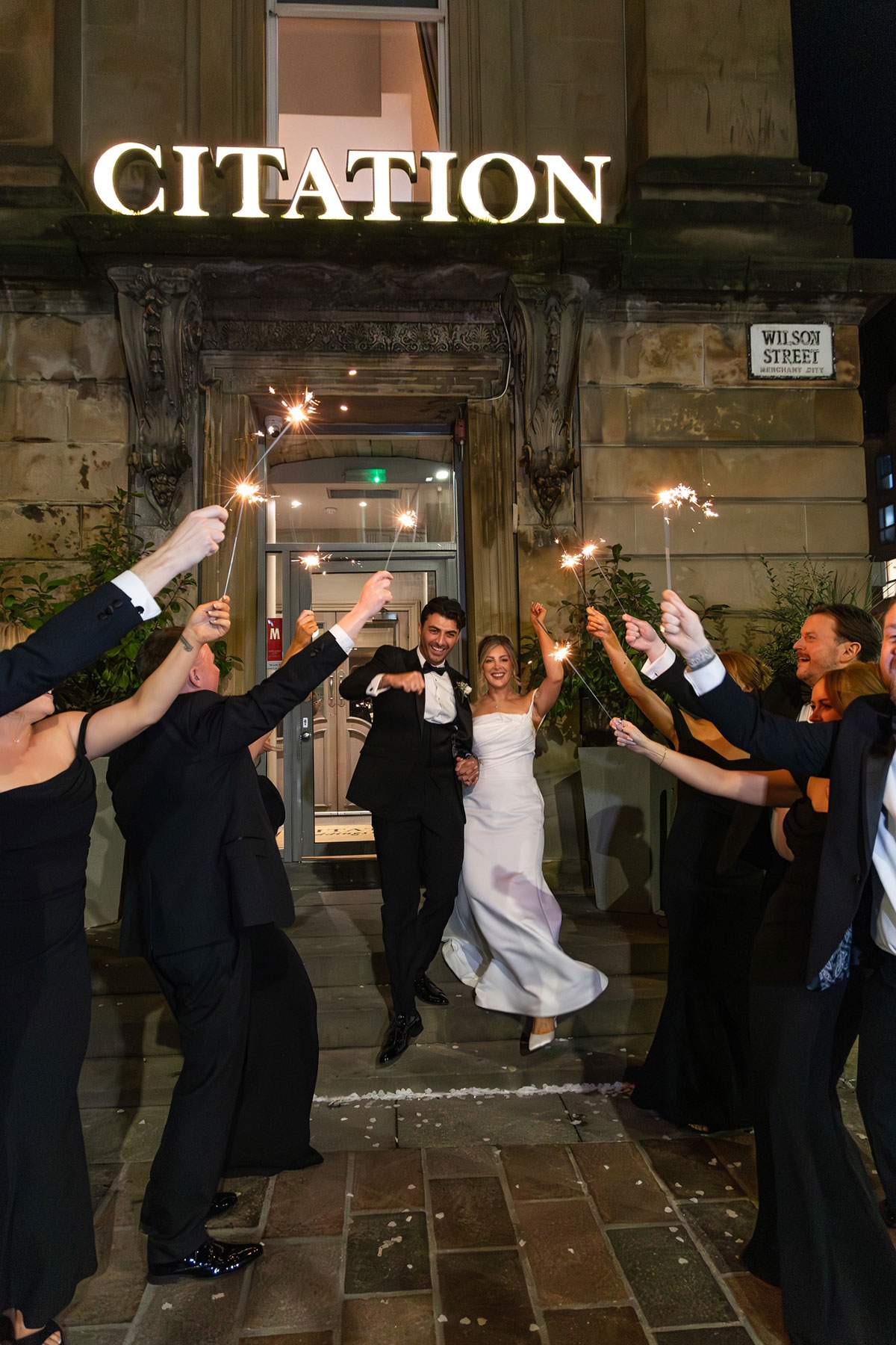 Bride and groom celebrating a sparkler exit outside Citation Glasgow after their city centre wedding reception