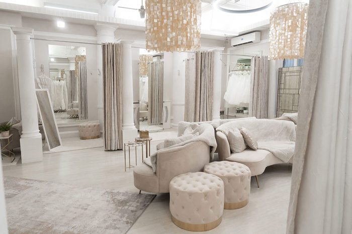 A room with white furniture and mirrors. The fitting rooms at Eleganza Sposa, a bridal boutique in Glasgow.