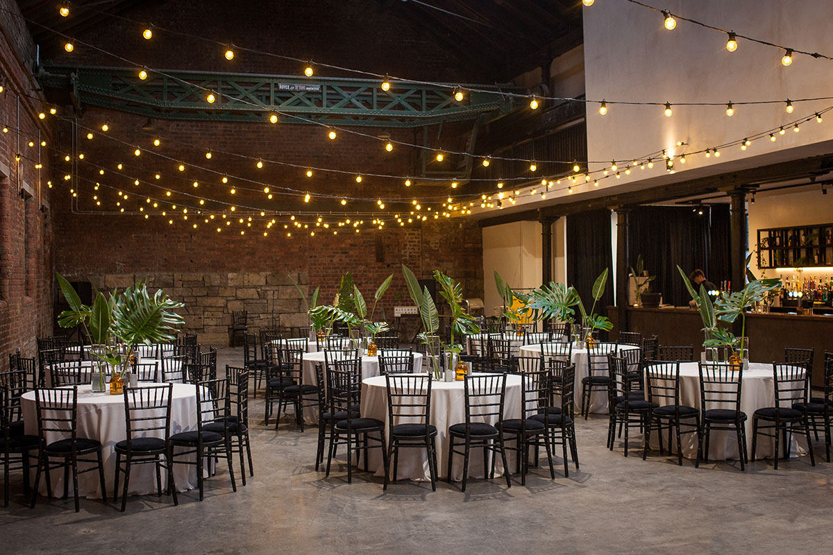 dinner set up at Engine Works with fairy lights and plants