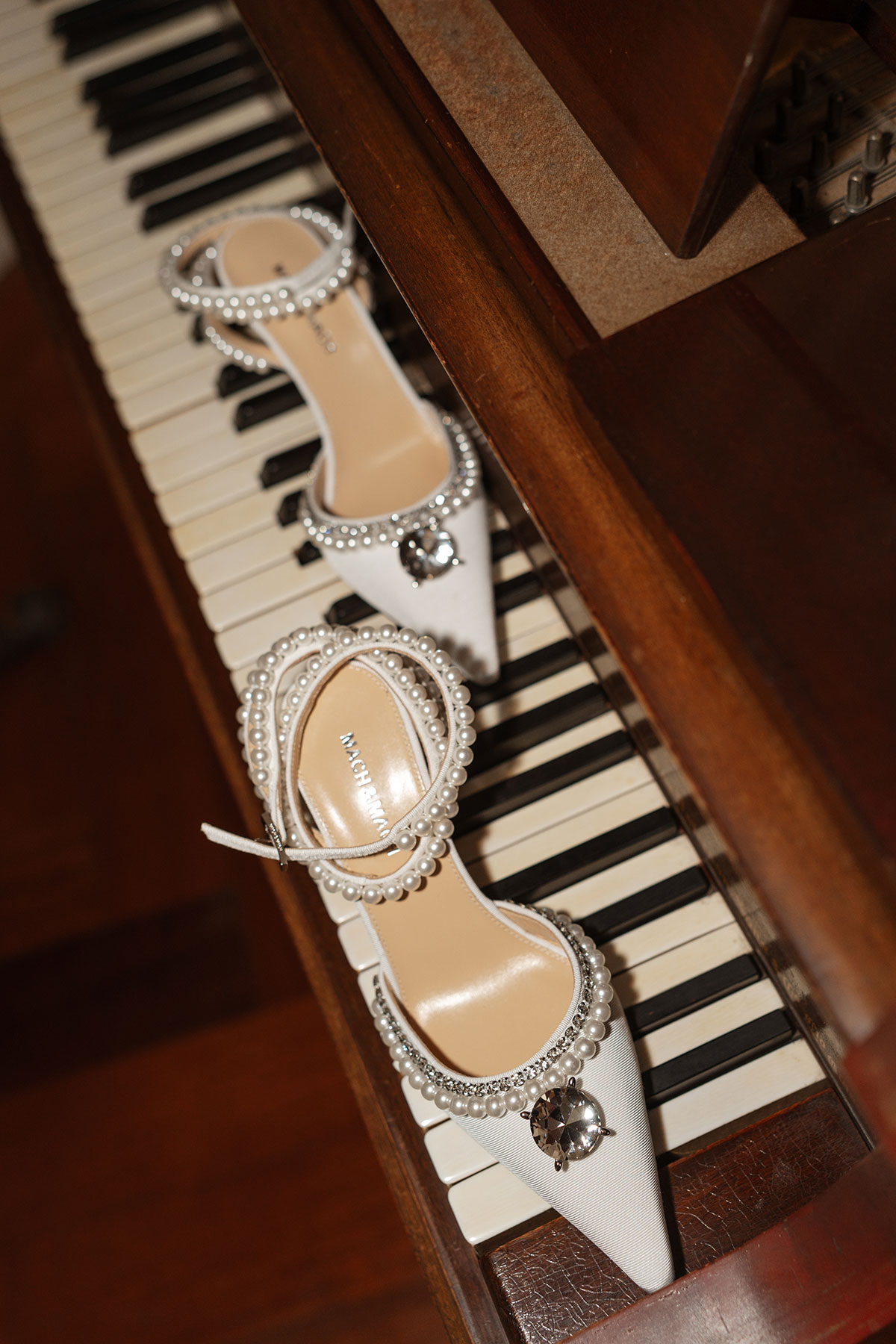 Bride's white Mach & Mach wedding shoes displayed on a piano before a Boturich Castle wedding in Scotland.