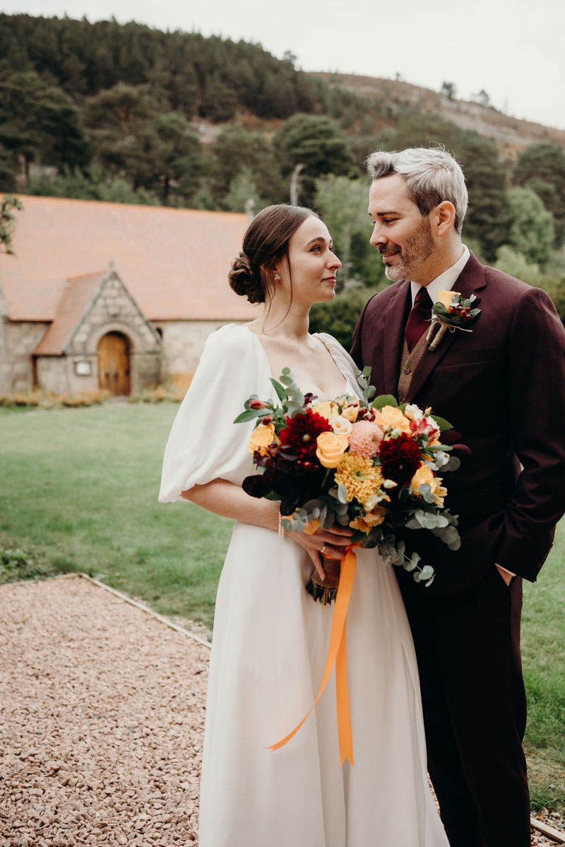 Mar Lodge Estate wedding, a bride and groom pictured outside small stone church