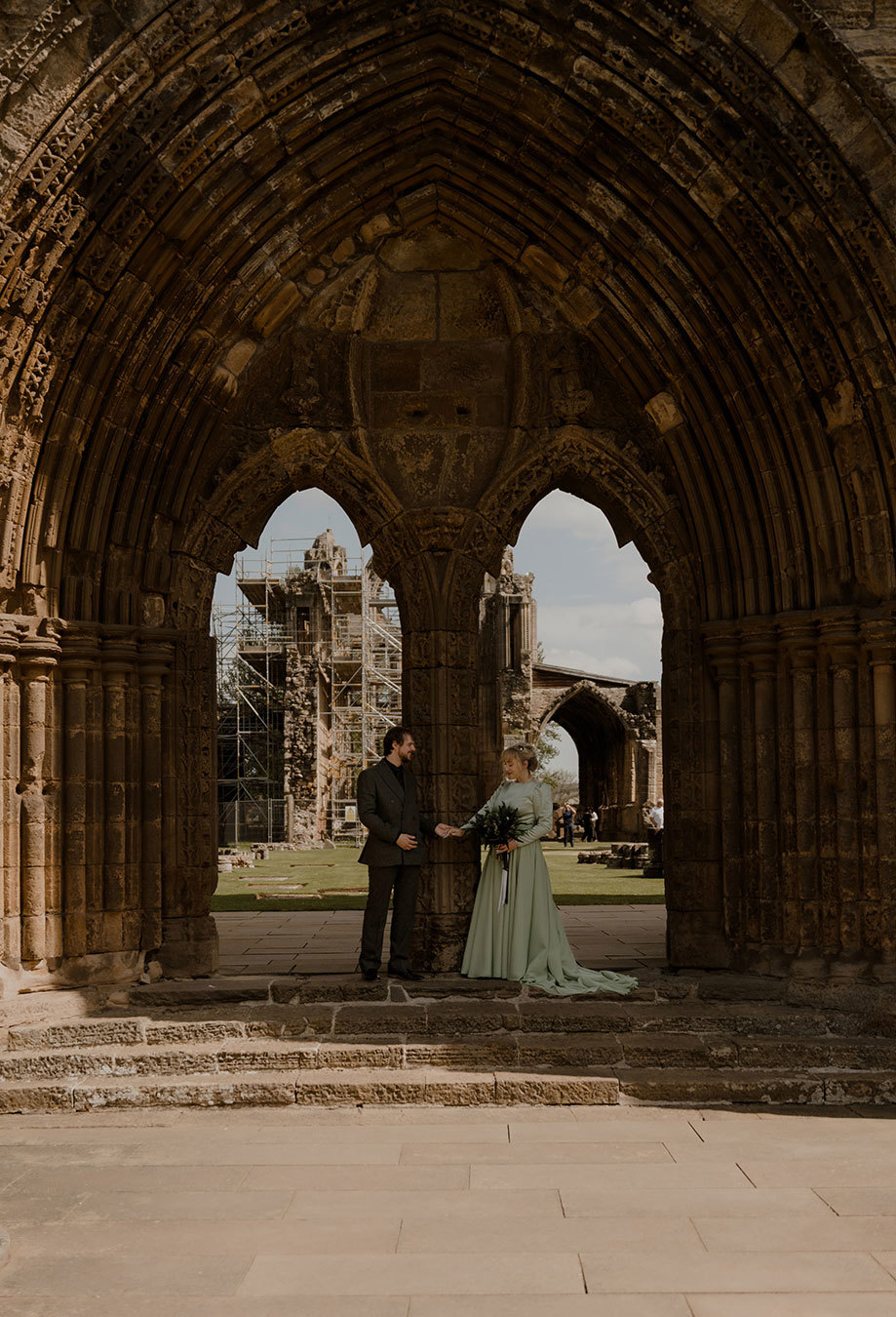 A bride and groom standing in a doorway at Elgin Cathedral