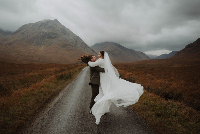 a groom swinging a bride around after their Glencoe mountain wedding