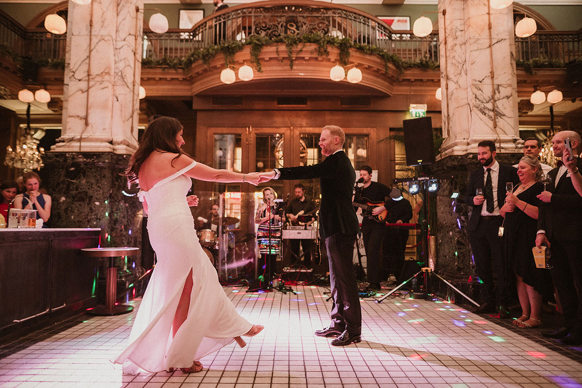 a bride and groom dancing on a white tiled floor at Scotsman Hotel