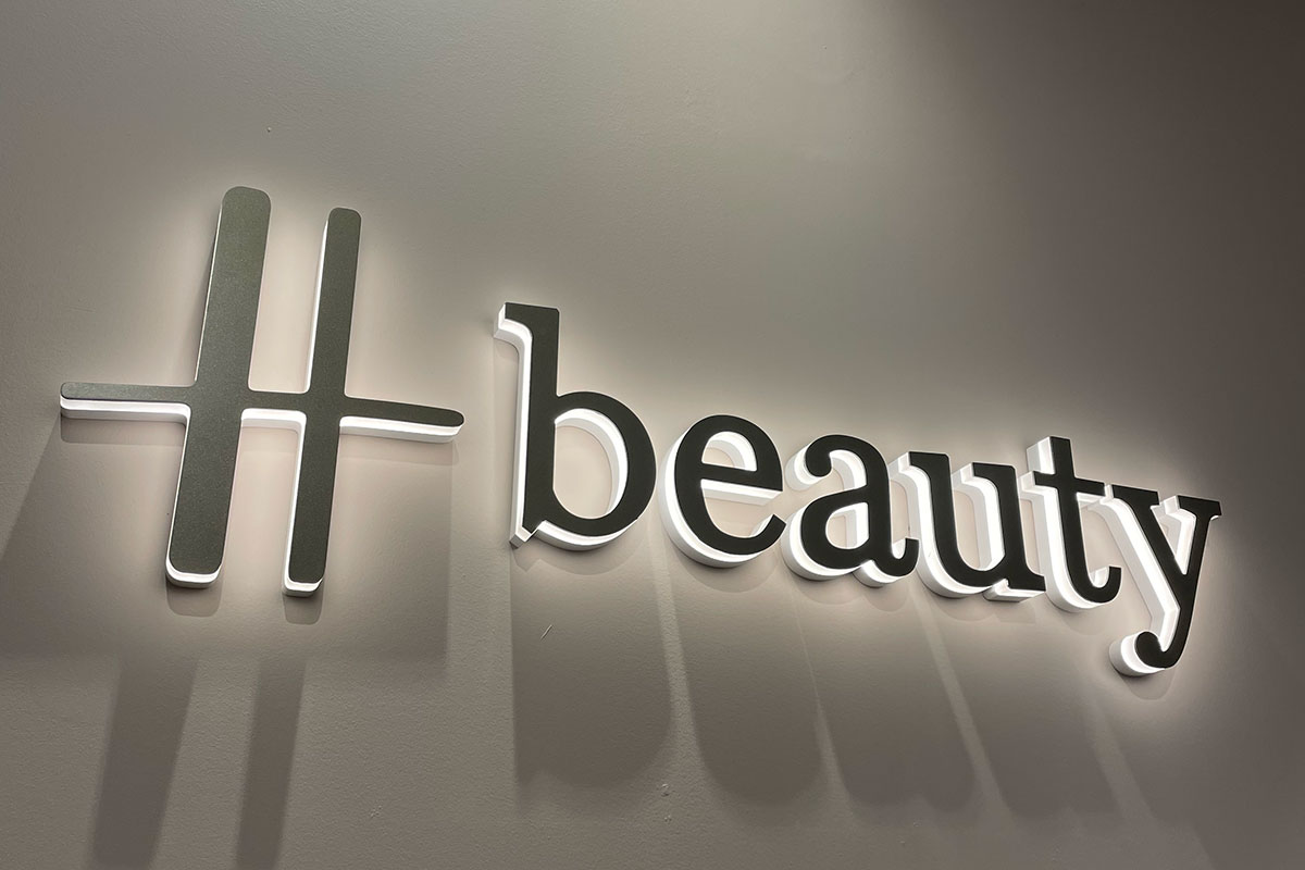 Illuminated H beauty store sign inside the Harrods beauty destination.