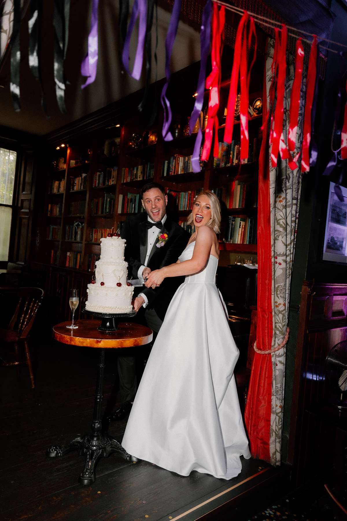 Kara and Rory cut their tiered wedding cake during their evening reception at Nauticus in Leith, Edinburgh.
