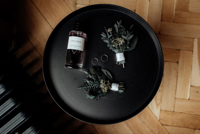 A Black Tray With Buttonholes And Bottle Of Perfume