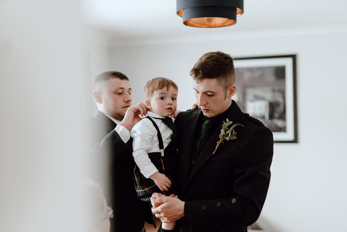 Groom getting ready holding small child