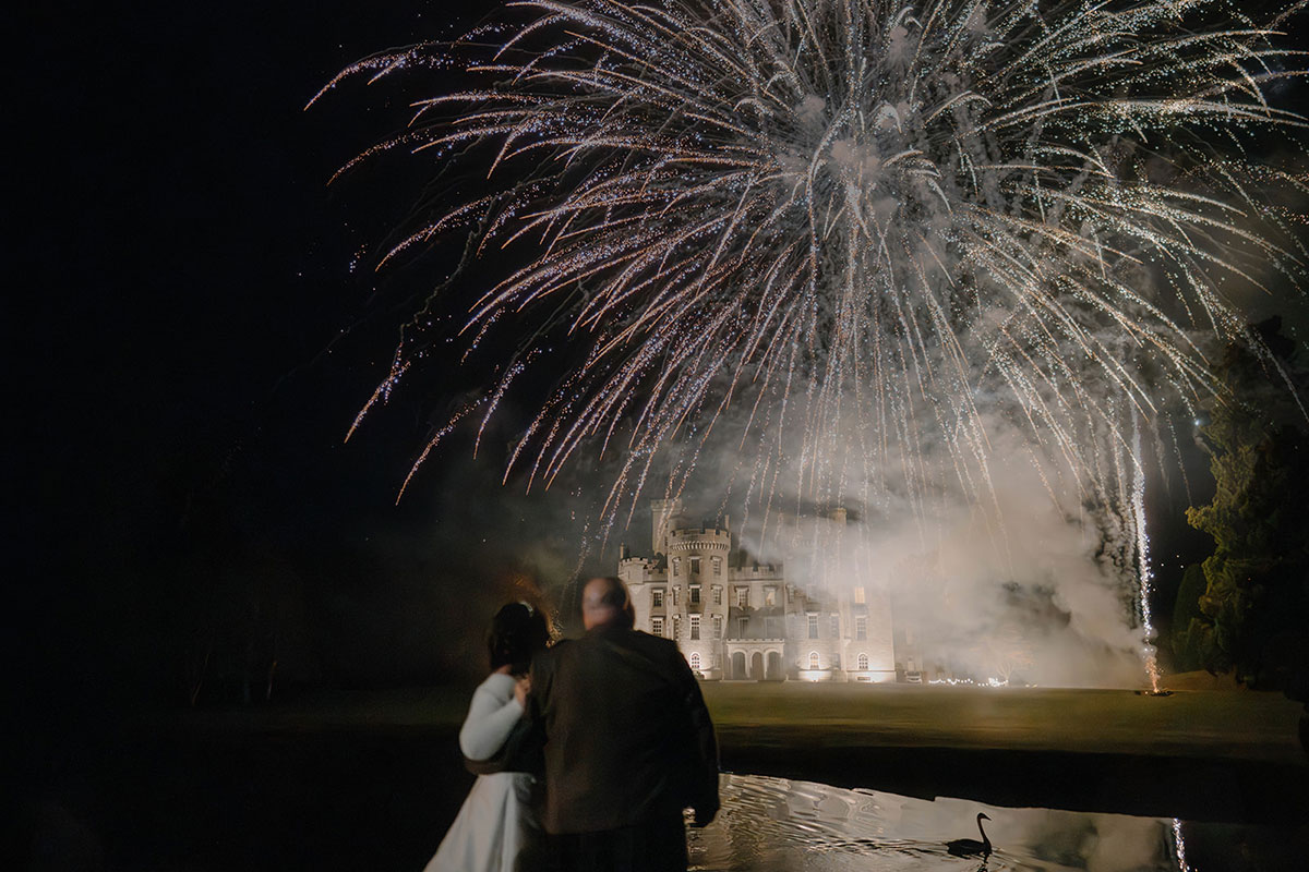 Fireworks lighting up the night sky above Cluny Castle during an exclusive-use Scottish castle wedding.