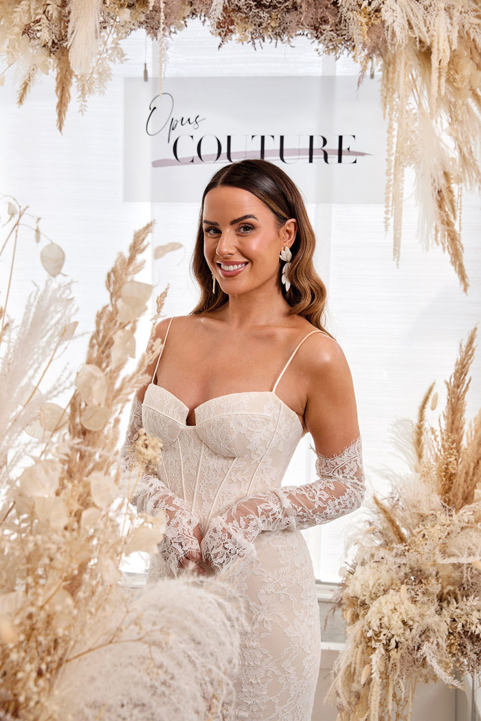 a woman wearing a lace wedding dress with long lace removable sleeves.