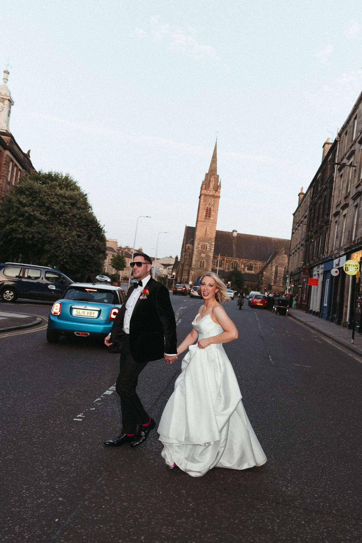 Kara and Rory cross an Edinburgh street in their wedding outfits on the way to their reception at Nauticus in Leith.