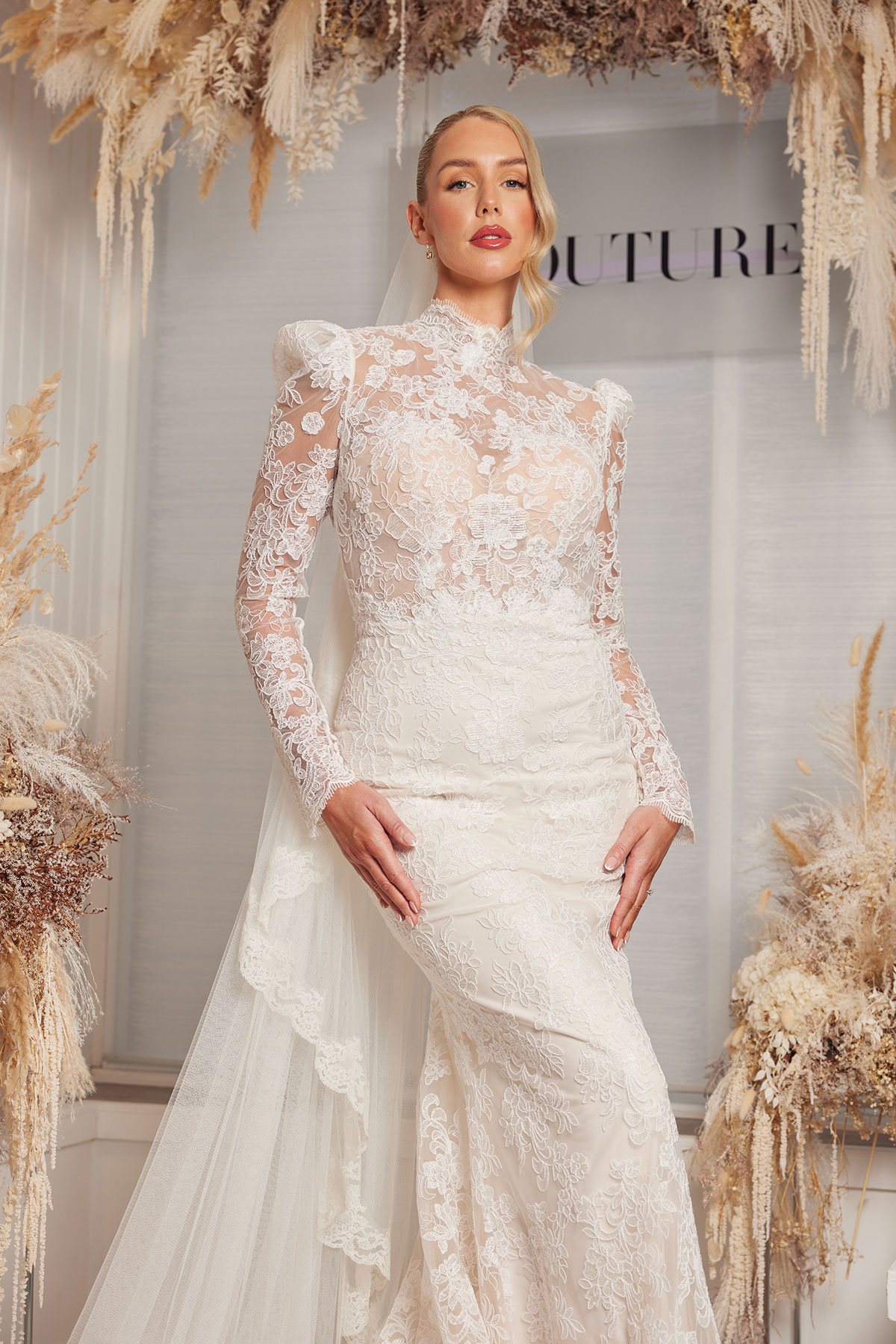 Model in long-sleeved lace bridal gown by Opus Couture