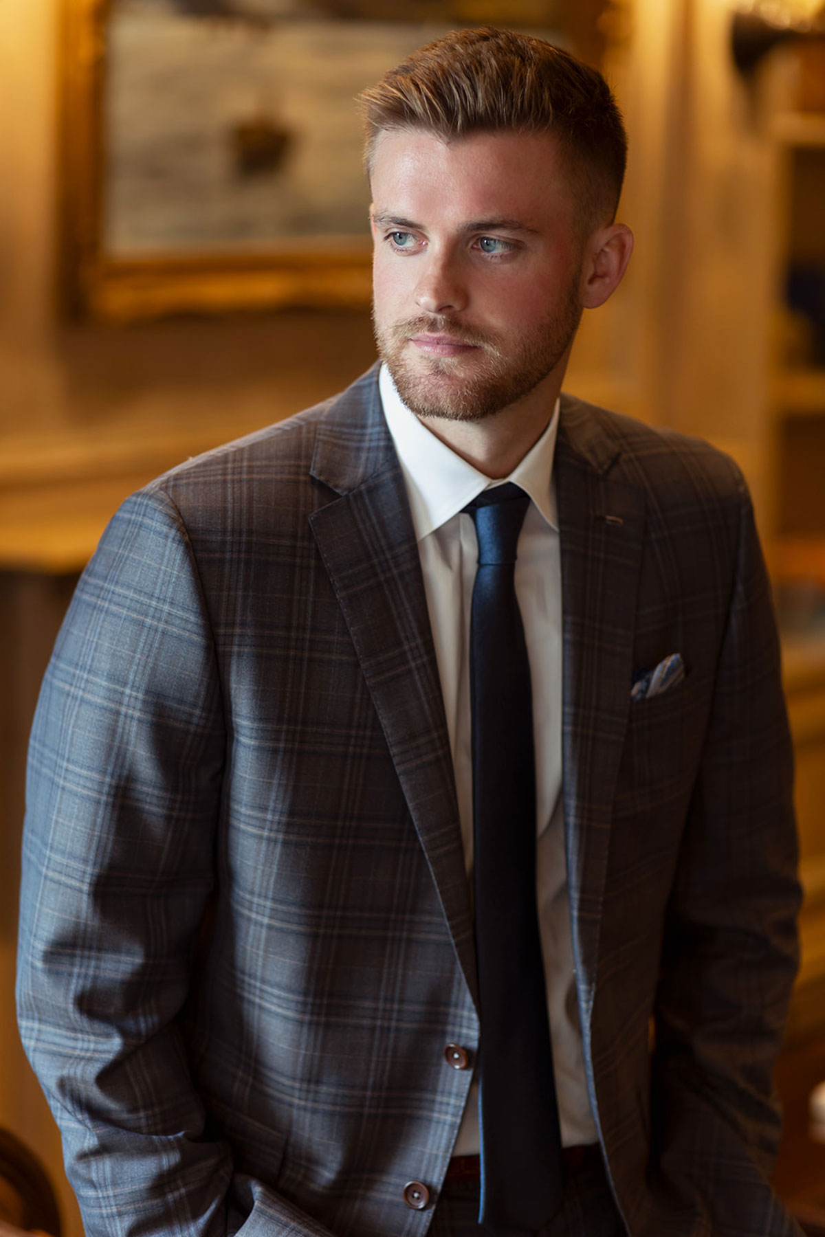 Groom portrait in grey checked suit and navy tie at Old Course Hotel Golf Resort & Spa wedding in St Andrews
