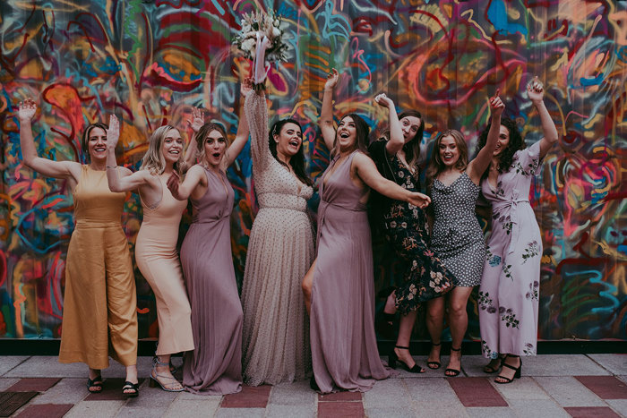 Wedding Group Portrait Against Colourful Mural At Barras Art And Design