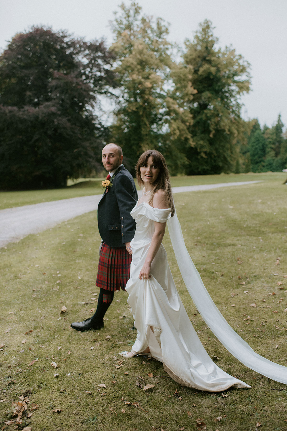 a bride and groom walking in the garden of Achnagairn Castle