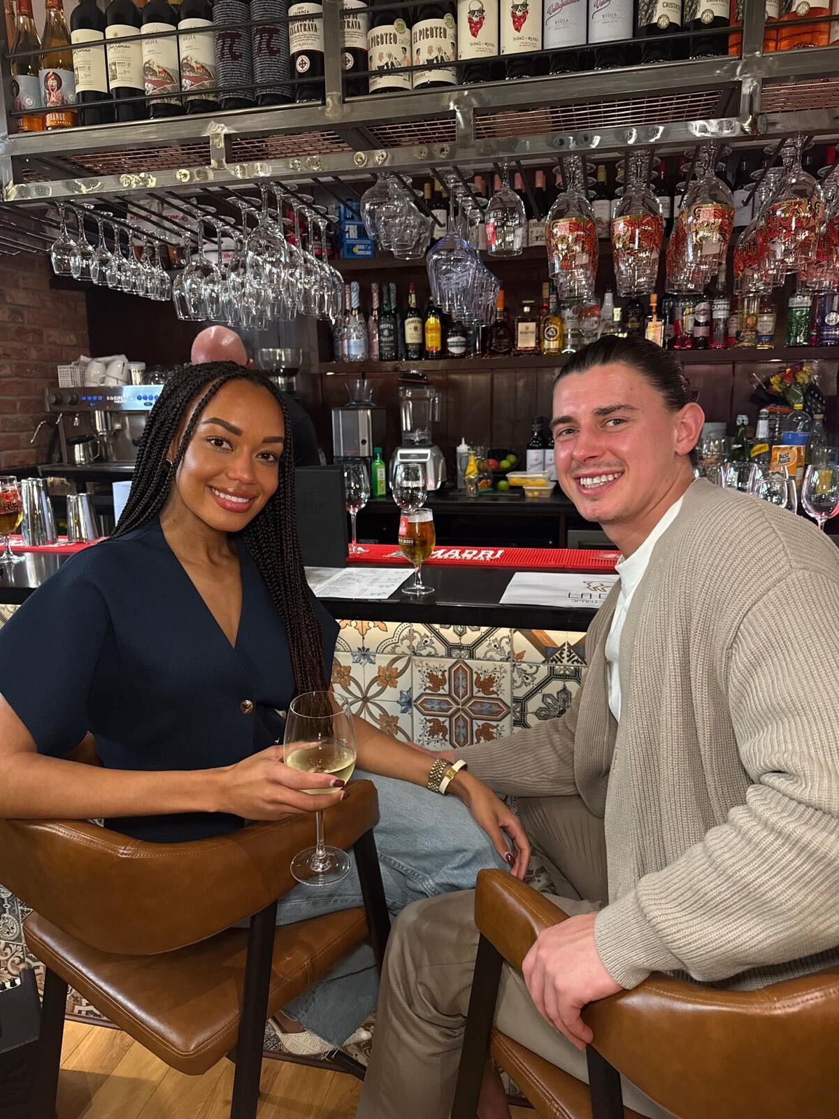 influencer maggie liz smith sits beside boyfriend jordan at a bar