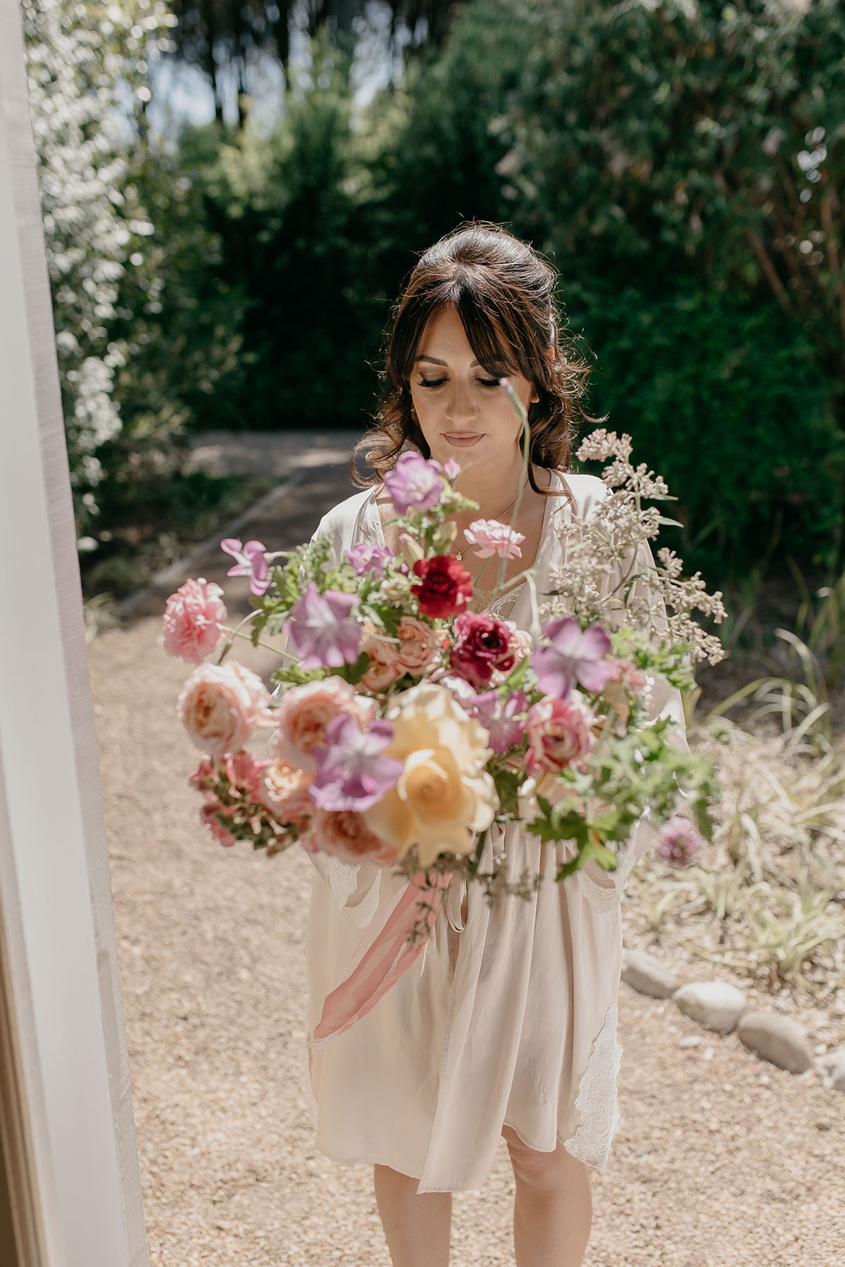 Bride holding colourful bouquet while getting ready before her Boschendal Wine Estate destination wedding in South Africa