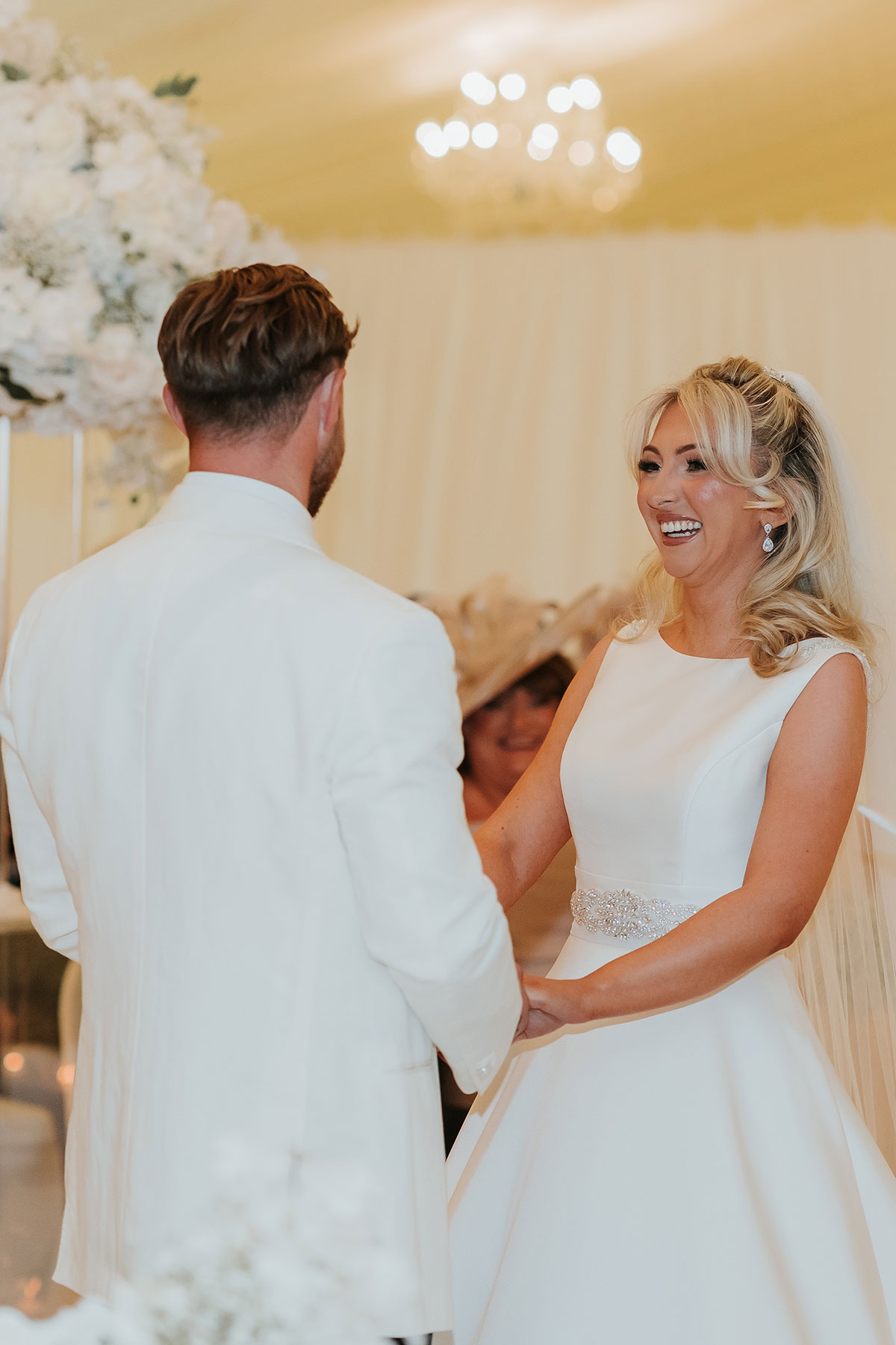Bride laughing during ceremony inside Ingliston Country Club marquee wedding space