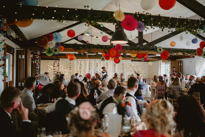 Guests watch the top table as groom performs his speech