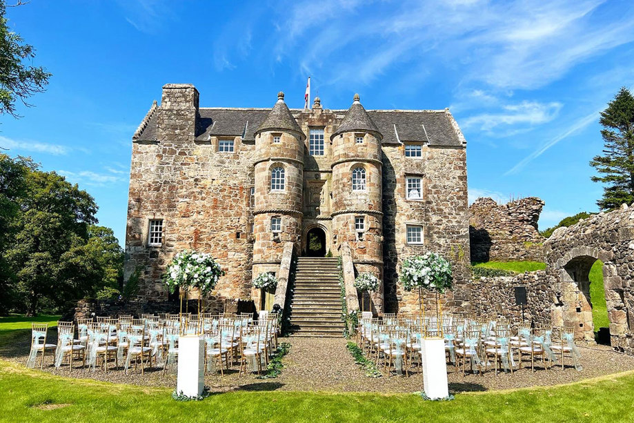 exterior of rowallan castle in the sunshine set up for outdoor ceremony