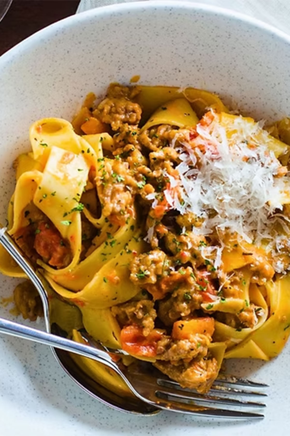 Bowl of pappardelle pasta with sauce and parmesan, illustrating a remote Italian cooking class wedding gift for food-loving couples