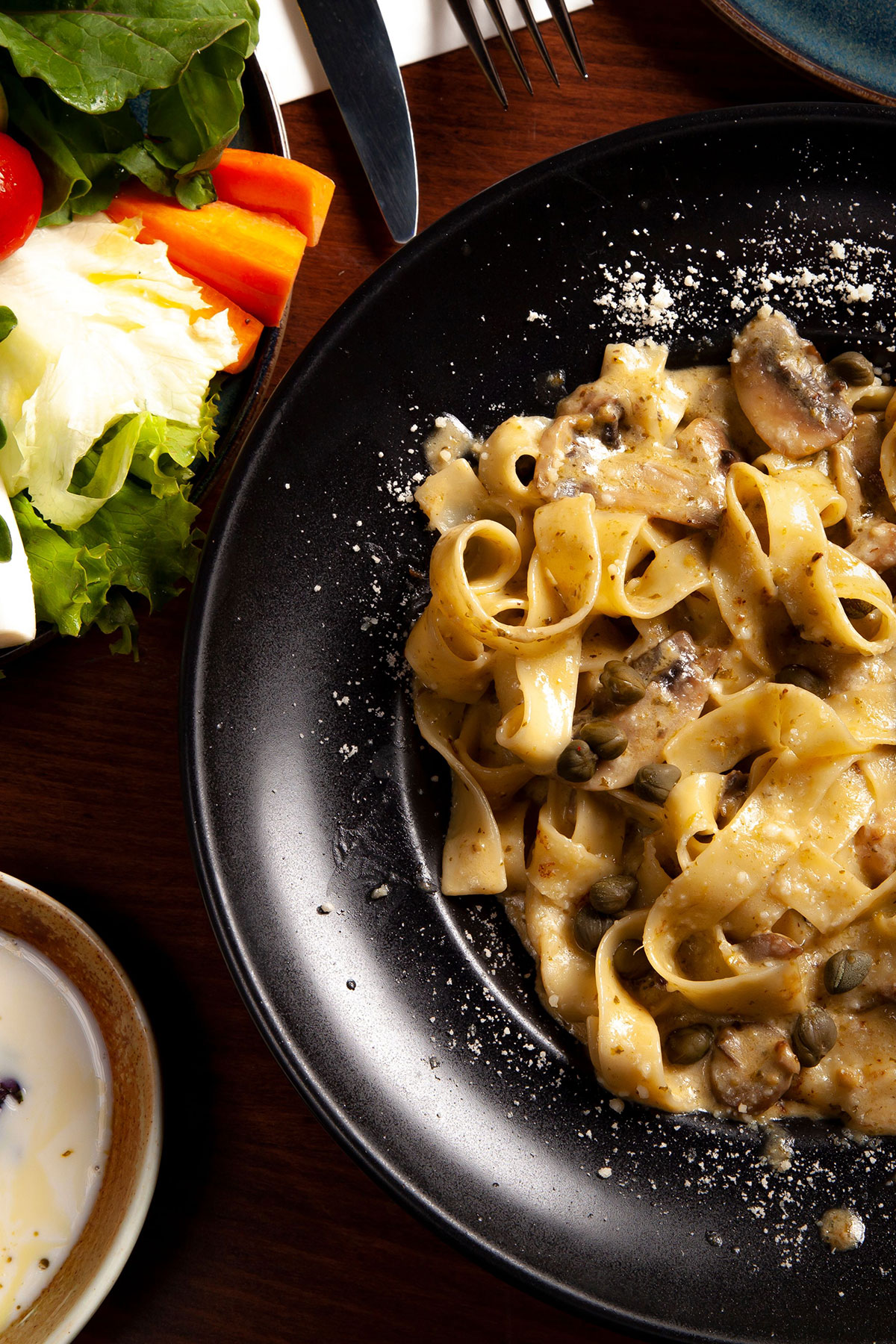 Bowl of pappardelle pasta with sauce and parmesan, illustrating a remote Italian cooking class wedding gift for food-loving couples