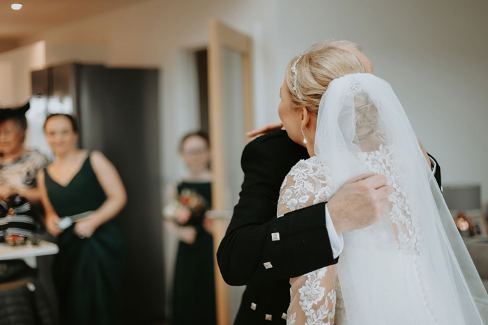 Bride hugs father during first look