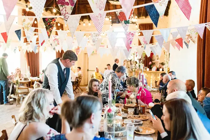 Guests eating during reception with bunting hanging above