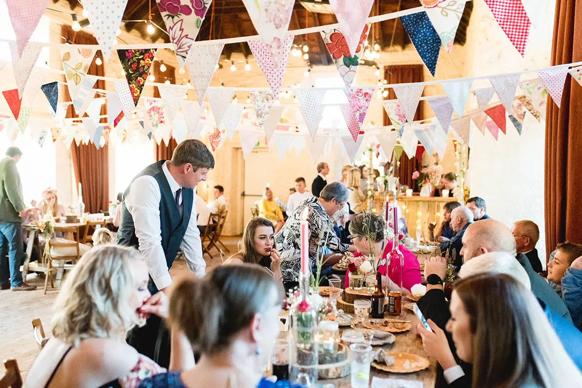 Guests eating during reception with bunting hanging above