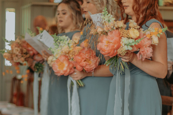 Image of the bridesmaids bouquets as they read hymn sheets