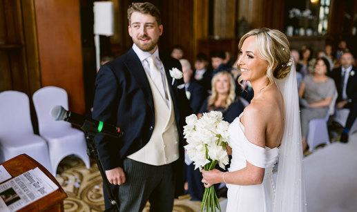 A smiling bride and groom during a wedding ceremony at Mar Hall.