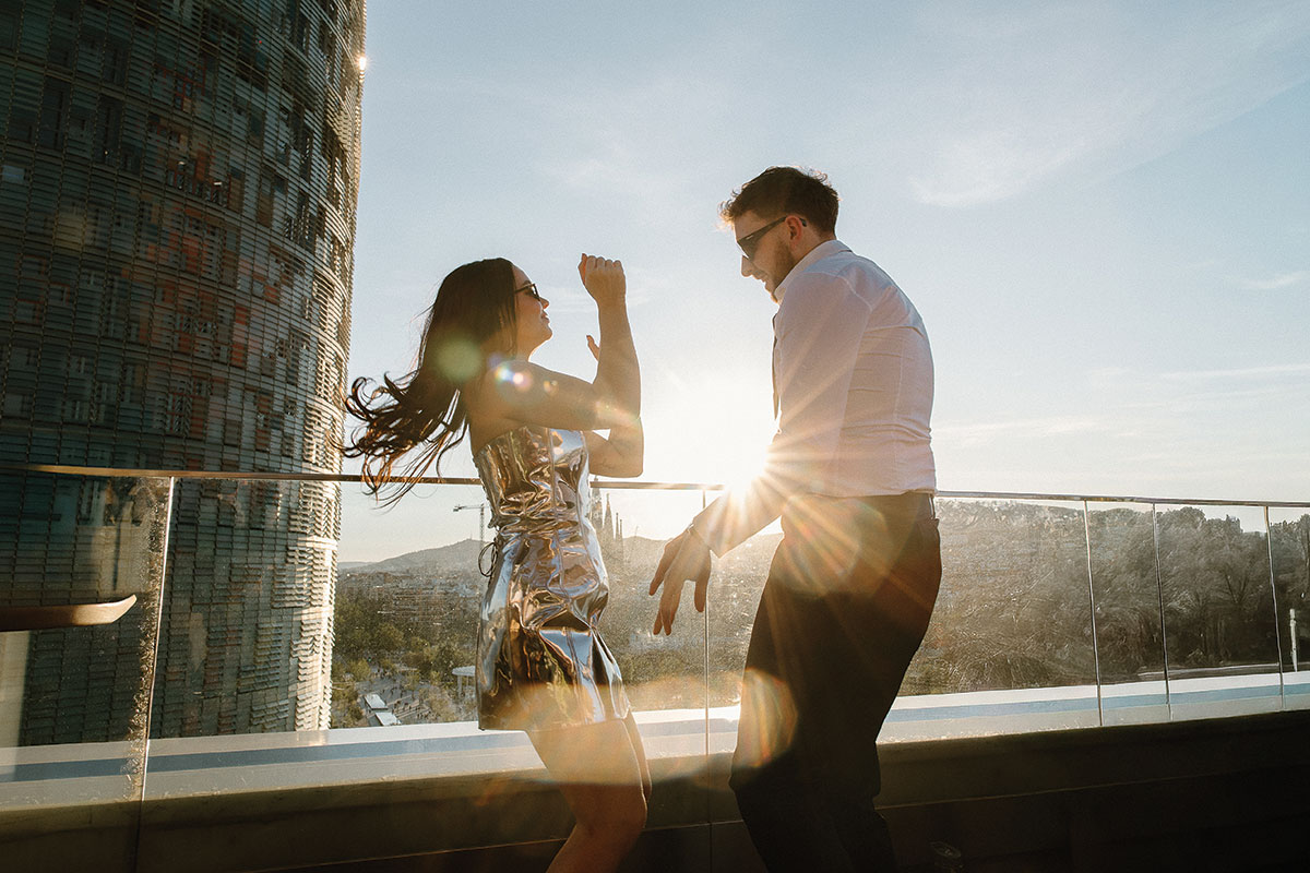 Newlyweds dancing at sunset on a rooftop terrace overlooking Barcelona after their wedding celebration
