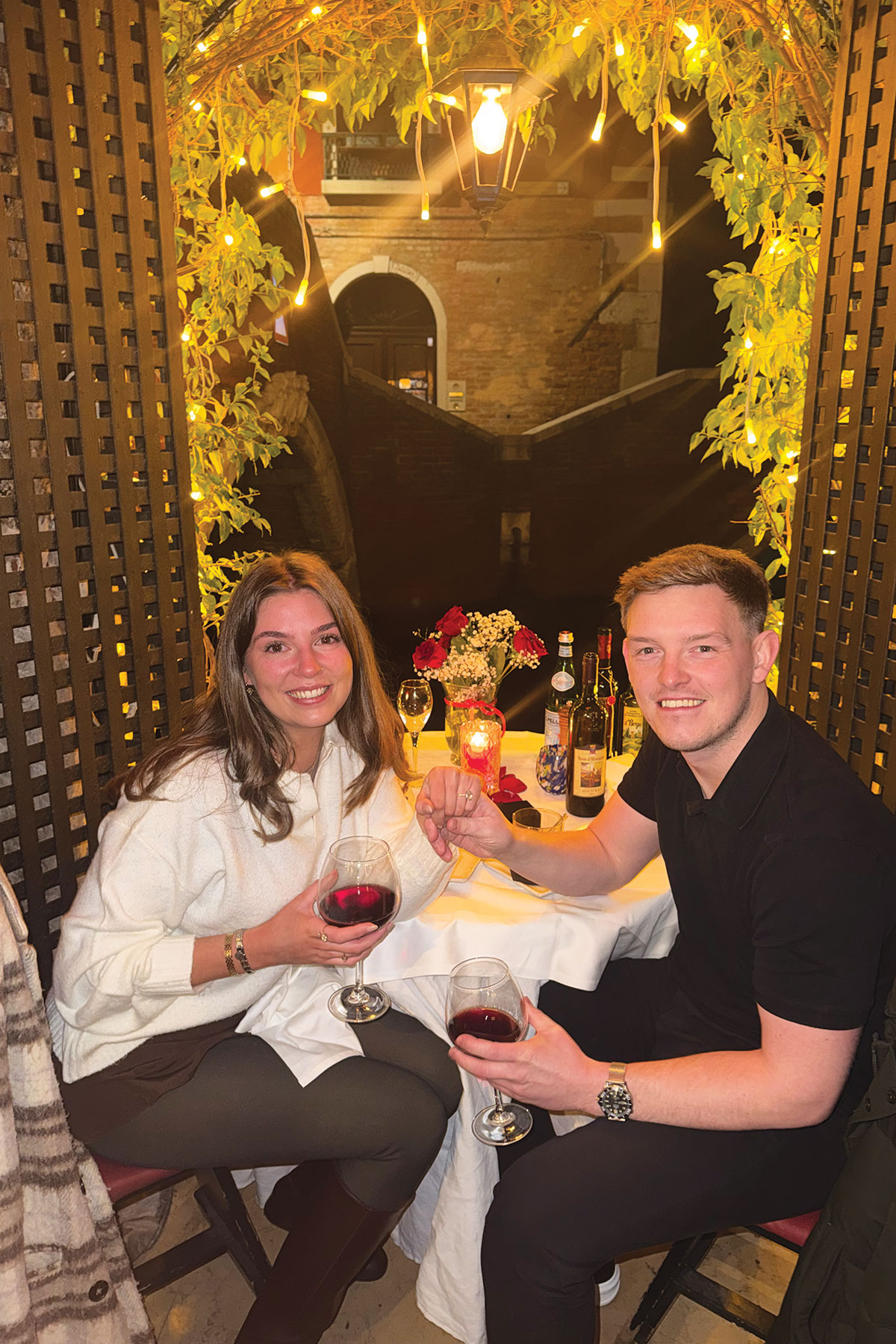Couple celebrating their engagement at a romantic canal-side restaurant in Venice after a James Porter & Son proposal.