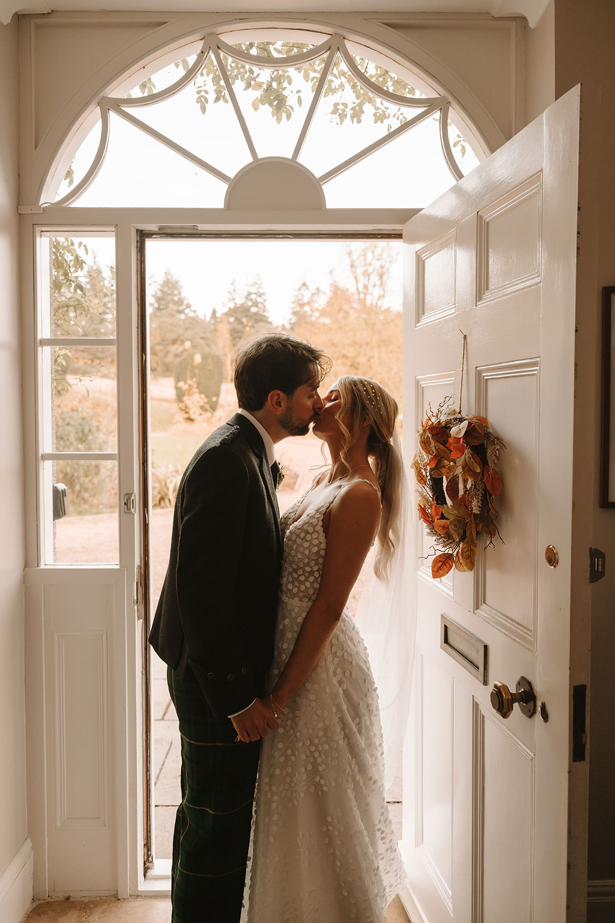 Bride and groom kissing in the doorway