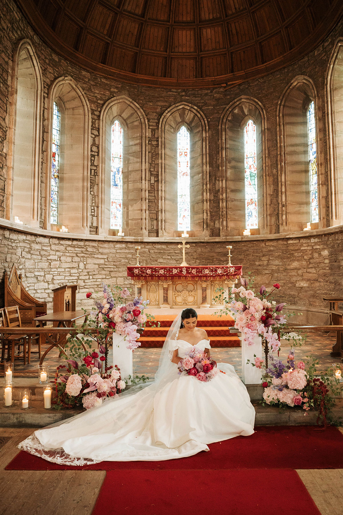 Bride posing with bouquet at altar in St Palladius Church during Drumtochty Castle Aberdeenshire wedding ceremony