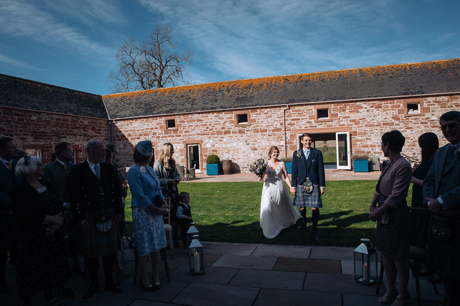 Bride and groom greeted by guests at their outdoor ceremony
