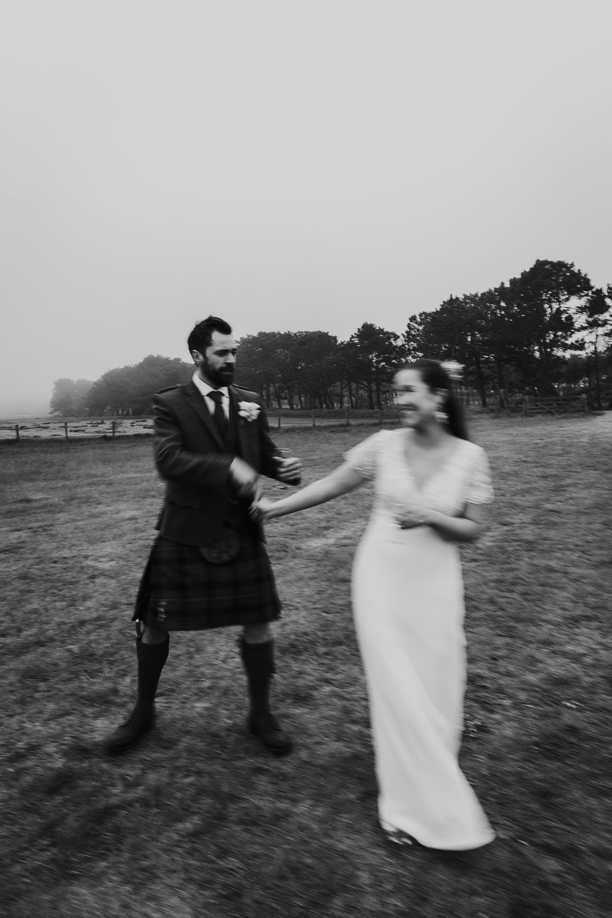 blurry black and white photo of bride and groom dancing on wedding day at harvest moon