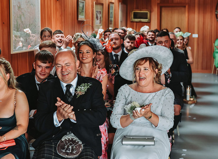 rows of seated wedding guests clapping