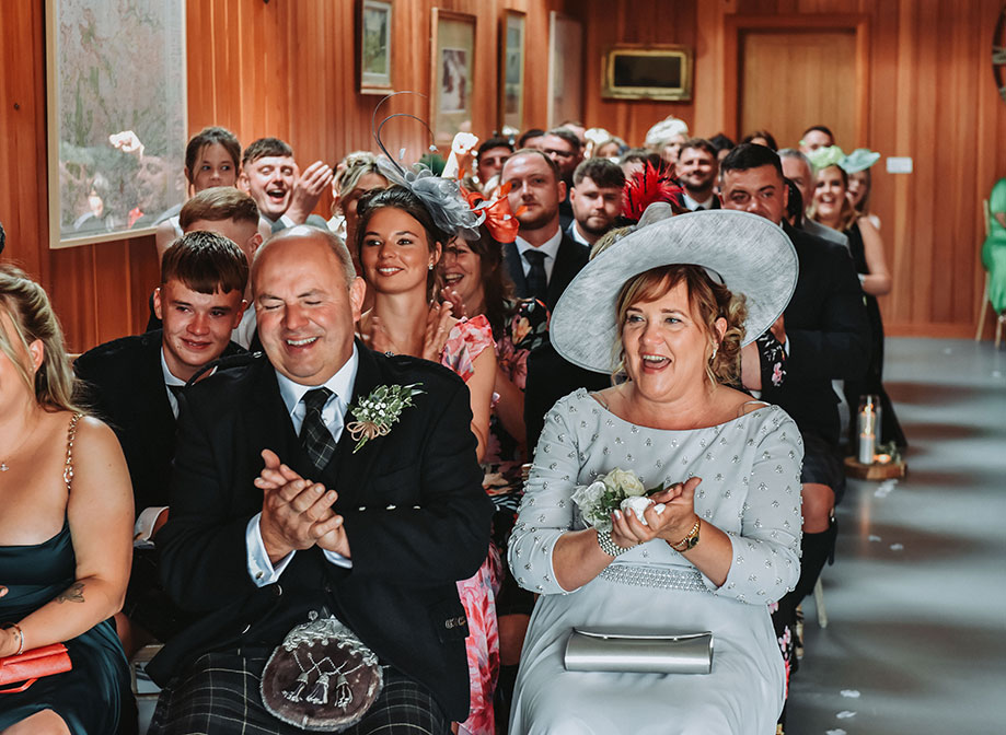 rows of seated wedding guests clapping