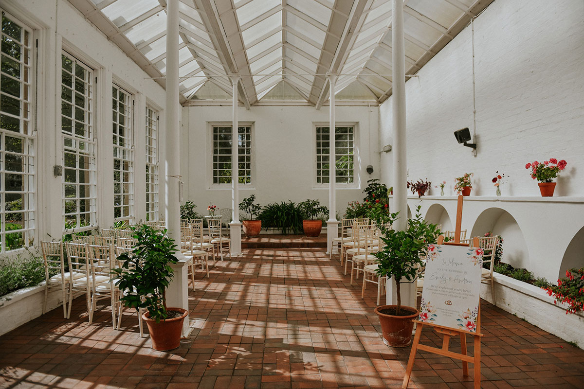 Bright conservatory ceremony space at Culzean Castle with natural light, terracotta flooring, potted plants and elegant wedding seating