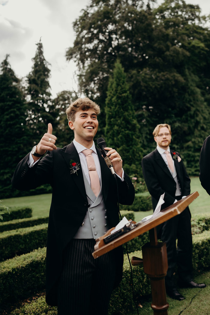 A person in a suit giving a thumbs up