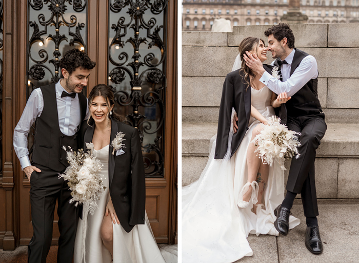 A groom in a black suit and a woman in a white wedding dress who is wearing the groom's suit jacket laugh together