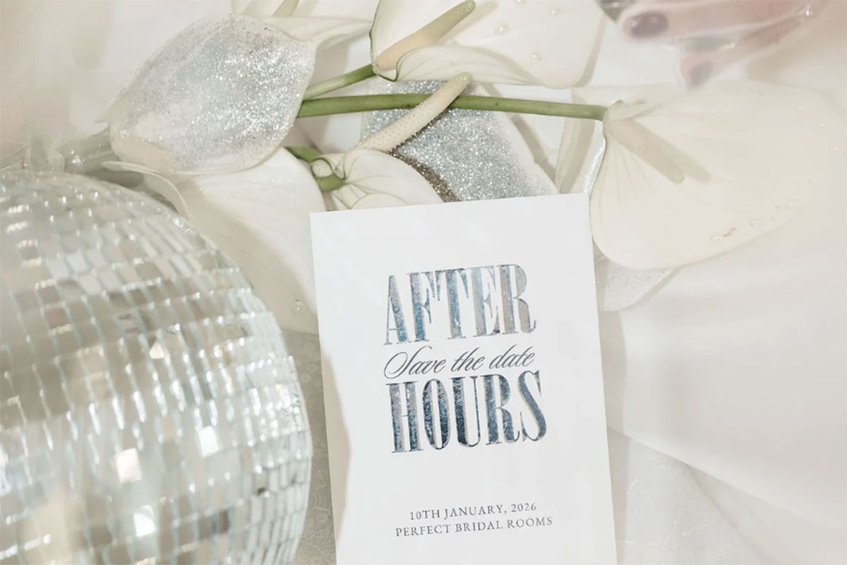 Flat lay of an ‘After Hours’ save-the-date card for Perfect Bridal Rooms, styled with white florals, soft tulle and a mirrored disco ball