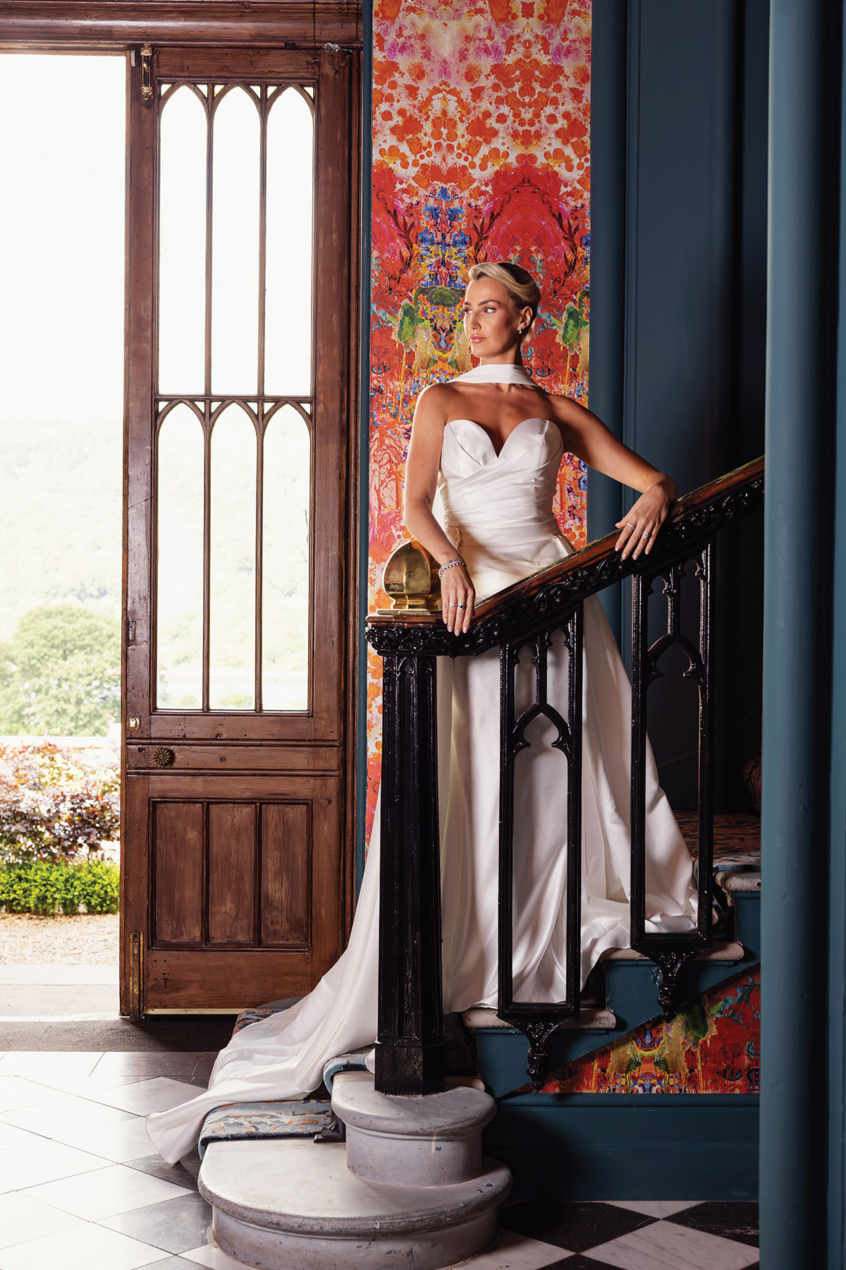 Bride wearing contemporary wedding dress and diamond jewellery on the staircase at Mar Hall