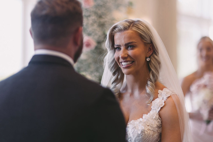 Bride smiles at groom during ceremony