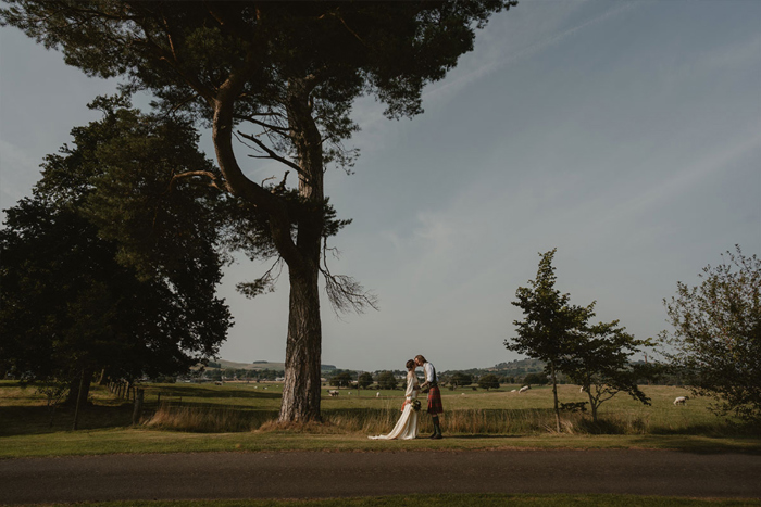 A Bride And Groom Under A Tree At Hartree Estates