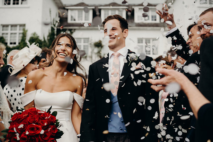 a bride and groom being showered in white confetti.