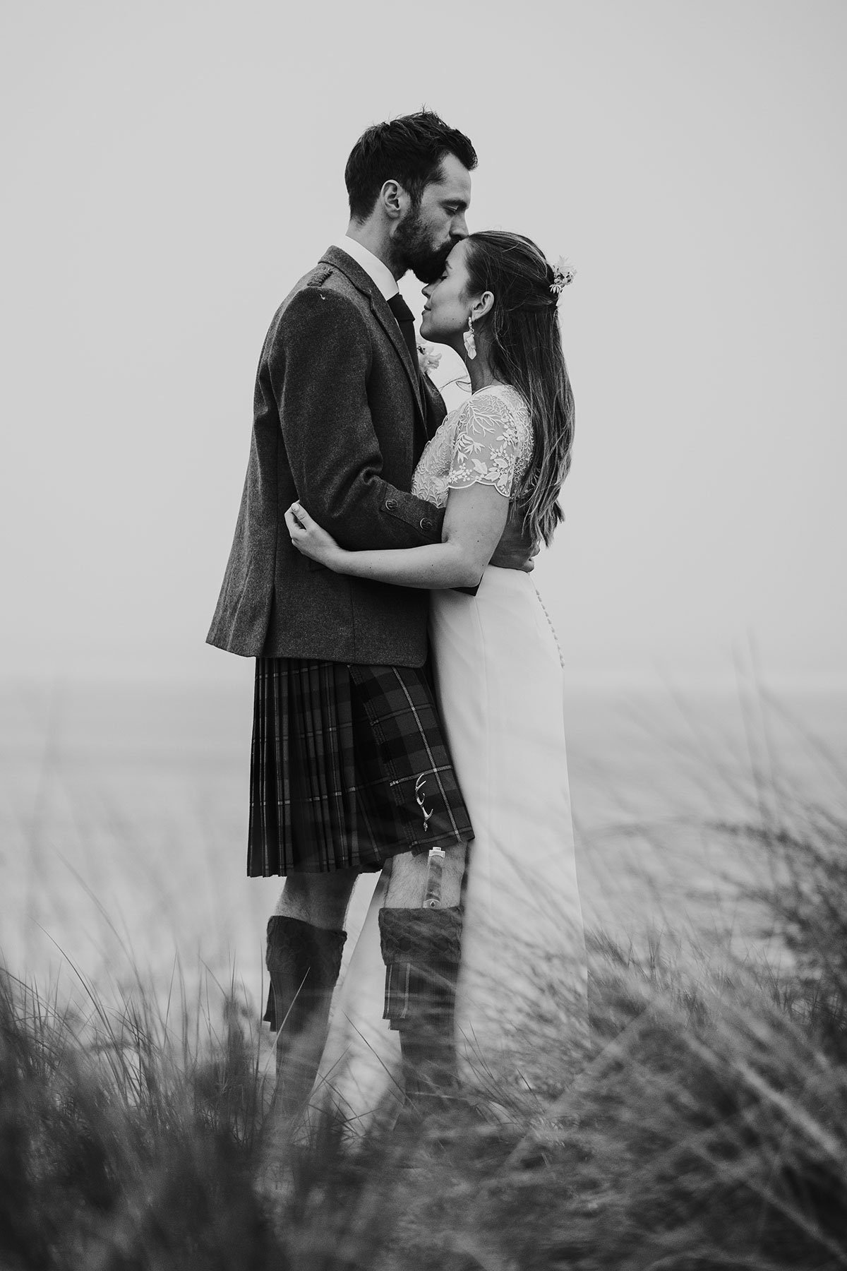 black and white picture of groom kissing brides forehead at harvest moon weddings