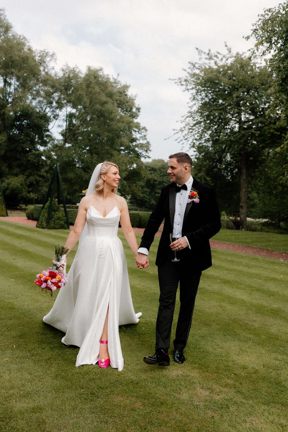Newlyweds Kara and Rory walk hand in hand through the grounds of Prestonfield House following their wedding ceremony.